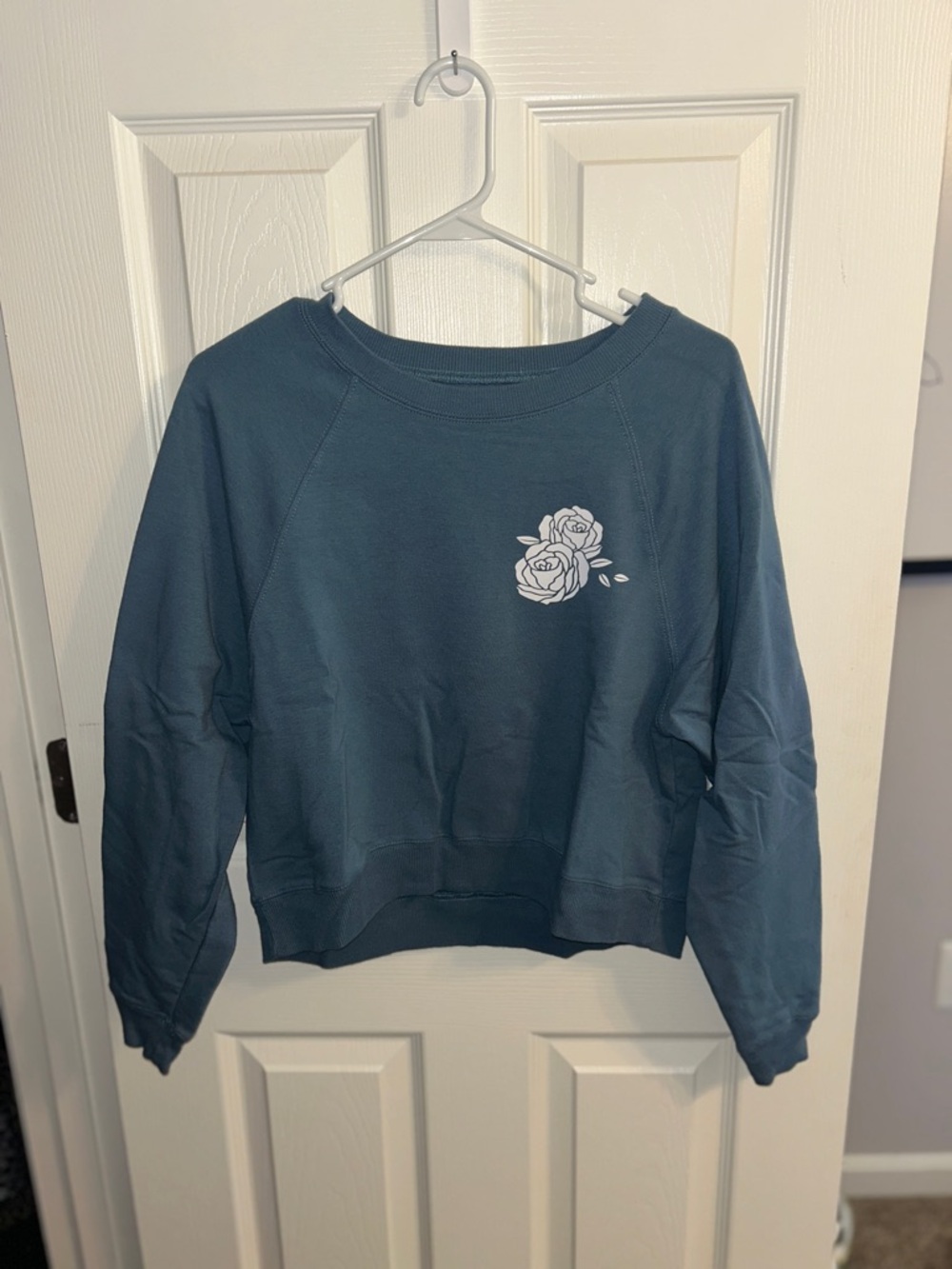 Rebellious One Blue Sweatshirt with White Rose Graphic
